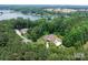 Expansive aerial view of lakefront home with lush green surroundings, nestled in a serene and secluded setting at 4616 Gold Finch Dr, Denver, NC 28037