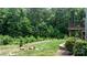 Well-maintained backyard with stone retaining wall, manicured lawn, and scenic views at 4616 Gold Finch Dr, Denver, NC 28037