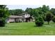 Well-manicured front yard featuring mature trees, a lush lawn, and a welcoming facade of the home at 4616 Gold Finch Dr, Denver, NC 28037