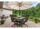 Outdoor patio features table with umbrella and seating overlooking a wooded yard at 4616 Gold Finch Dr, Denver, NC 28037