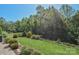 Fenced backyard featuring landscaped greenery, a lush lawn, and mature trees at 464 Granite Lake Ct, Denver, NC 28037