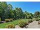 Patio area with lush lawn, landscaping and mature trees behind a fence at 464 Granite Lake Ct, Denver, NC 28037