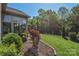 Beautifully landscaped backyard with a patio, lush greenery, and a fenced perimeter at 464 Granite Lake Ct, Denver, NC 28037