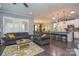 Open-concept living room with hardwood floors flows into a kitchen featuring a breakfast bar and modern pendant lighting at 464 Granite Lake Ct, Denver, NC 28037