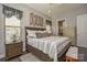 Primary bedroom featuring hardwood floors, a decorative accent wall, and an ensuite bathroom at 464 Granite Lake Ct, Denver, NC 28037