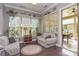 Sunroom with plentiful windows and cozy seating opens to a screened patio at 464 Granite Lake Ct, Denver, NC 28037