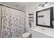 Charming bathroom features shiplap walls, updated vanity, and shower with floral shower curtain at 4916 Ritchie Rd, Lincolnton, NC 28092