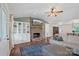 Open-concept living room featuring a stone fireplace with a TV, large sectional sofa, and a view of the dining area at 4916 Ritchie Rd, Lincolnton, NC 28092