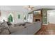 Cozy living room with a stone fireplace, TV, large windows, and a comfortable gray sofa with an ottoman at 4916 Ritchie Rd, Lincolnton, NC 28092
