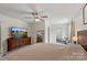 Spacious main bedroom featuring a ceiling fan, dresser with TV, and an ensuite bathroom at 4916 Ritchie Rd, Lincolnton, NC 28092