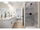 Modern bathroom featuring dual vanities, a sleek shower with gray tile, and contemporary fixtures at 515 Dixie Dr, Mooresville, NC 28115