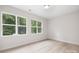 Bright bedroom with large windows offering views of lush greenery, and light wood flooring at 515 Dixie Dr, Mooresville, NC 28115