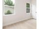 Clean bedroom featuring light hardwood floors, white trim and doors, and windows with backyard views at 515 Dixie Dr, Mooresville, NC 28115