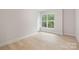 Light-filled bedroom with hardwood floors, trim, and a large window offering lush green views at 515 Dixie Dr, Mooresville, NC 28115