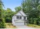 New construction home with a two-car garage and white siding, nestled among mature trees at 515 Dixie Dr, Mooresville, NC 28115