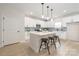 Modern kitchen with white cabinets, stainless steel appliances, and a quartz countertop island with barstool seating at 515 Dixie Dr, Mooresville, NC 28115