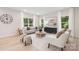 Elegant living room with neutral tones, large windows, stylish furnishings, and wood flooring at 515 Dixie Dr, Mooresville, NC 28115