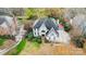 An aerial view of a two-story house with a dark roof, surrounding trees and shrubbery, plus a private driveway at 520 Beacon Knoll Ln, Fort Mill, SC 29708
