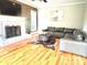 Cozy living room featuring hardwood floors, a fireplace, a mounted TV, and a comfortable leather sofa at 520 Beacon Knoll Ln, Fort Mill, SC 29708