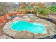 Aerial view of a backyard pool with stone accents, an outdoor kitchen, and a spa under a pergola at 520 Beacon Knoll Ln, Fort Mill, SC 29708