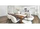 Open dining area with a stylish wood table, chairs, and an adjacent modern kitchen at 5540 Pamplona Way, Charlotte, NC 28214