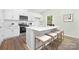 Modern white kitchen with an island, stainless steel appliances, and barstool seating at 5540 Pamplona Way, Charlotte, NC 28214