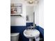 Stylish half bath with a pedestal sink, a gold faucet, modern lighting, and half-painted wall detail at 6013 Pivot Ct, Charlotte, NC 28205