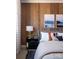 Serene bedroom featuring natural wood paneling, calming artwork, and soft, inviting bedding at 6013 Pivot Ct, Charlotte, NC 28205