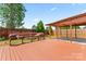 A wooden bench with throw pillows sits on the home's deck overlooking the well-manicured lawn and fenced yard at 8309 Shinkansen Dr, Charlotte, NC 28213
