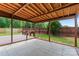Covered patio features tile flooring, a wood-paneled ceiling, and backyard access to the fenced-in yard at 8309 Shinkansen Dr, Charlotte, NC 28213