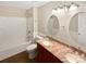 Bathroom with double vanity, marble countertop, oval mirrors, and tub-shower combination at 903 Furman Ct, Fort Mill, SC 29708