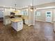 Open kitchen with island, stainless steel appliances, and custom pendant lighting and flooring at 903 Furman Ct, Fort Mill, SC 29708