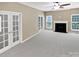 Open living room with neutral walls, fireplace, carpet floors, and french doors to outdoor spaces at 903 Furman Ct, Fort Mill, SC 29708