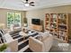 Bright living room with modern furniture, striped rug, and open shelving with plants and books at 903 Furman Ct, Fort Mill, SC 29708