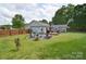 Large backyard with lush lawn, a fire pit area, and a deck, ideal for entertaining and relaxing at 9051 Country Barn Ct, Charlotte, NC 28273
