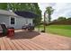 A spacious wooden deck offers a relaxing outdoor space with comfortable seating and a shaded umbrella at 9051 Country Barn Ct, Charlotte, NC 28273