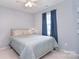 Comfortable bedroom featuring a window with blue curtains and a bed at 9051 Country Barn Ct, Charlotte, NC 28273