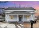 Charming gray home boasts a covered front porch with columns and a classic rocking chair at 92 Saint Charles Ne Ave, Concord, NC 28025