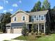 Charming two-story home featuring a three-car garage and manicured front yard at 9945 Cask Way, Huntersville, NC 28078
