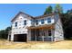 New two-story home with an attached two-car garage and covered front porch framed by large windows at 9945 Cask Way, Huntersville, NC 28078