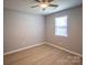 This bedroom features one window with blinds, a ceiling fan, and wood-look flooring at 1004 Johnson St, Charlotte, NC 28206