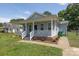 Charming single-story home with a welcoming front porch, landscaped yard, and blue siding at 1004 Johnson St, Charlotte, NC 28206