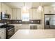 A bright kitchen with stainless steel appliances, white cabinetry, stylish backsplash, and large center island at 1004 Johnson St, Charlotte, NC 28206