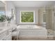 Well-lit bathroom featuring a bathtub, glass shower, and vanity with bright mirror at 1014 Harrogate Ln, Matthews, NC 28104