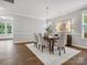Formal dining room features hardwood floors, a modern chandelier, designer wall art, and ample natural light at 1014 Harrogate Ln, Matthews, NC 28104