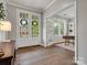 Open foyer with white french doors leading into a home office featuring a large window and custom built-in shelving at 1014 Harrogate Ln, Matthews, NC 28104