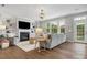 Cozy living room with hardwood floors, a fireplace, built-in bookshelves, large windows, and comfortable seating at 1014 Harrogate Ln, Matthews, NC 28104