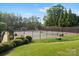 Community tennis courts surrounded by trees, a fence and beautiful landscaping at 1014 Harrogate Ln, Matthews, NC 28104