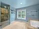 Bathroom featuring tiled shower, soaking tub, and vanity with granite countertop at 10545 Mount Holly Huntersville Rd, Huntersville, NC 28078