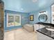 Bright bathroom with blue walls, soaking tub, and granite countertops around dual sinks at 10545 Mount Holly Huntersville Rd, Huntersville, NC 28078